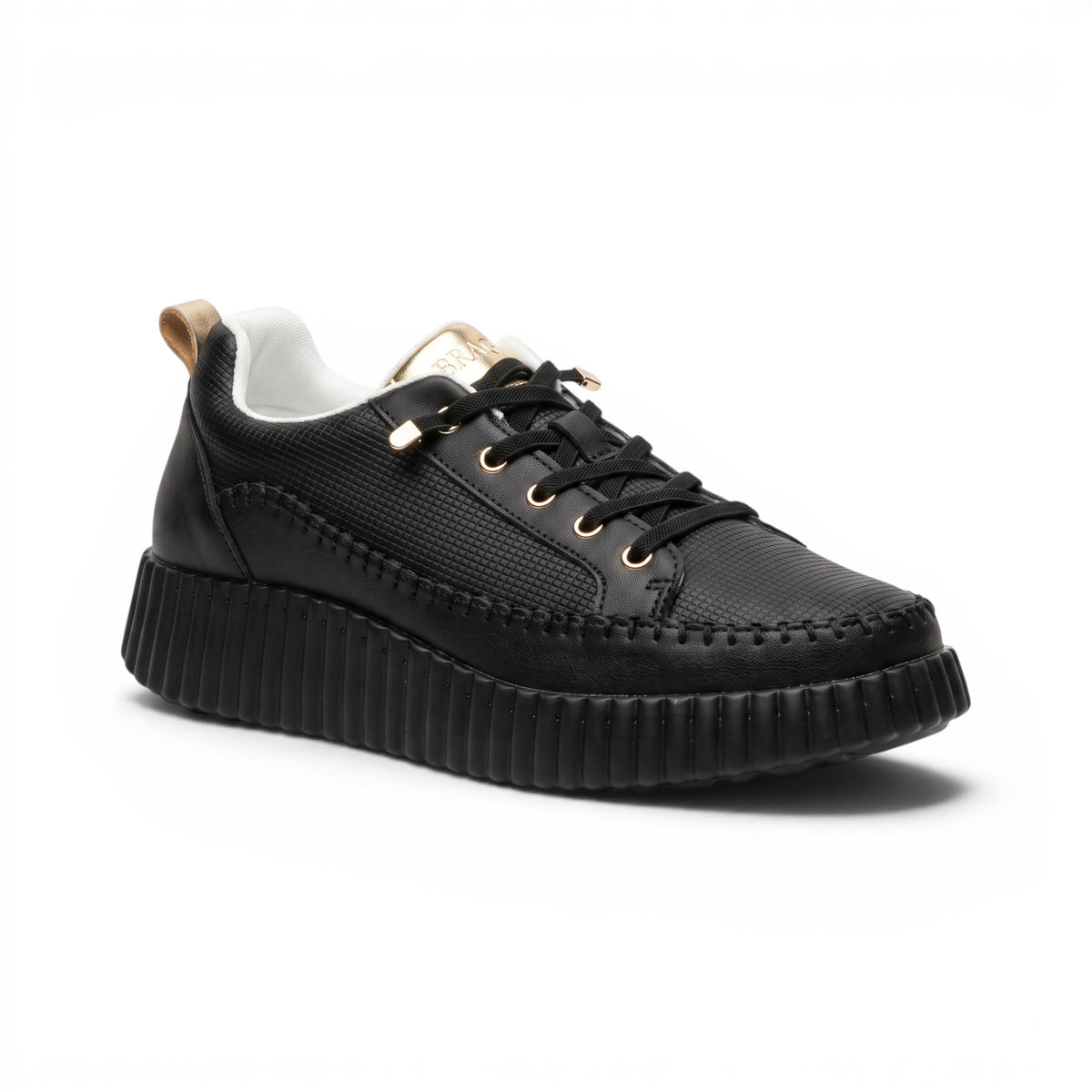 A black low-top platform sneaker with a textured upper, black laces, gold-tone eyelets, a white interior lining, and a chunky ridged sole, shown on a white background.