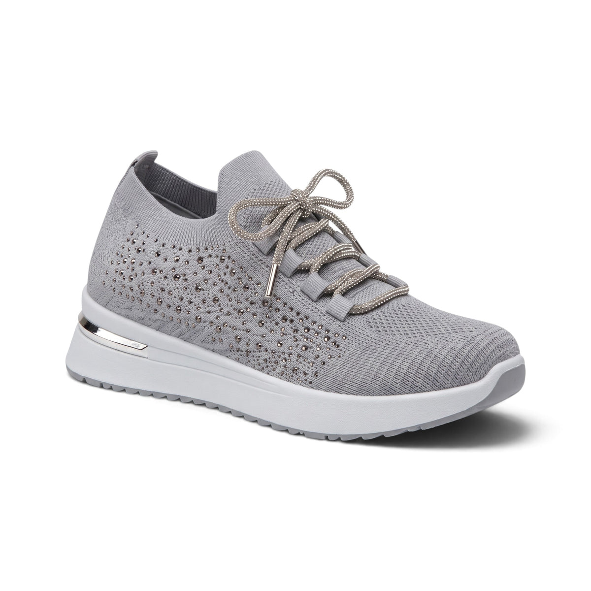 A light gray knit slip-on sneaker with matching gray laces, a textured perforated upper, and a chunky white sole with a metallic accent, shown on a white background.