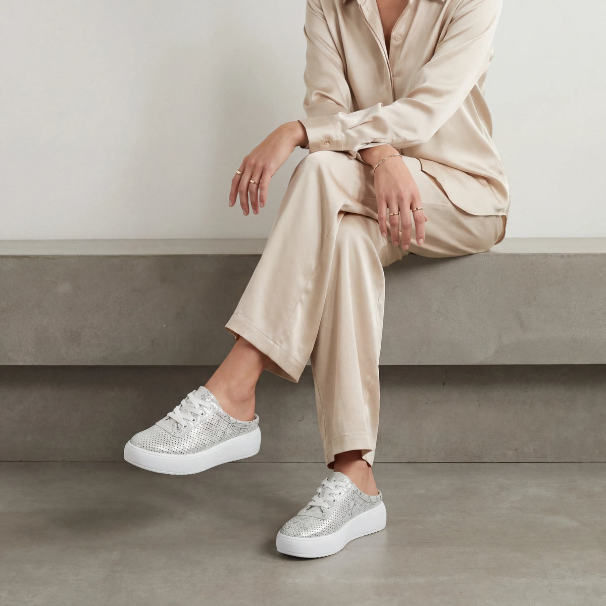 A grey and silver metallic platform mule sneaker with a perforated upper, easy slip-on design and lightweight cushioned sole for everyday wear.